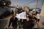 Palestinians carry the body of a casualty of Israeli strikes, at the Al-Aqsa Martyrs hospital morgue in Deir el-Balah in the central Gaza Strip on May 18, 2025. Gaza's civil defence agency said Israeli air strikes on May 18 killed at least 33 people, more than half of them children, a day after Israel announced an expanded military campaign. (Photo by Eyad BABA / AFP)