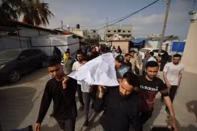 Palestinians carry the body of a casualty of Israeli strikes, at the Al-Aqsa Martyrs hospital morgue in Deir el-Balah in the central Gaza Strip on May 18, 2025. Gaza's civil defence agency said Israeli air strikes on May 18 killed at least 33 people, more than half of them children, a day after Israel announced an expanded military campaign. (Photo by Eyad BABA / AFP)
