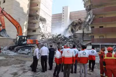 This handout picture released by the Iranian Red Crescent on June 14, 2025, show Iranian Red Crescent volunteers gathered in front of a building destroyed in an Israeli strike in Tehran. The Iranian foreign ministry on June 14 said it would be