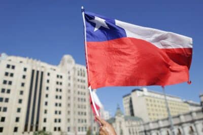 A supporter of Chile's new President Gabriel Boric holds a Chilean flag while waiting for his arrival to La Moneda Palace after his inauguration in Santiago, on March 11, 2022. Leftist former student leader Gabriel Boric sworn in Friday as Chile's youngest-ever president, with plans to turn the country that for decades has served as a neoliberal laboratory into a greener, more egalitarian
